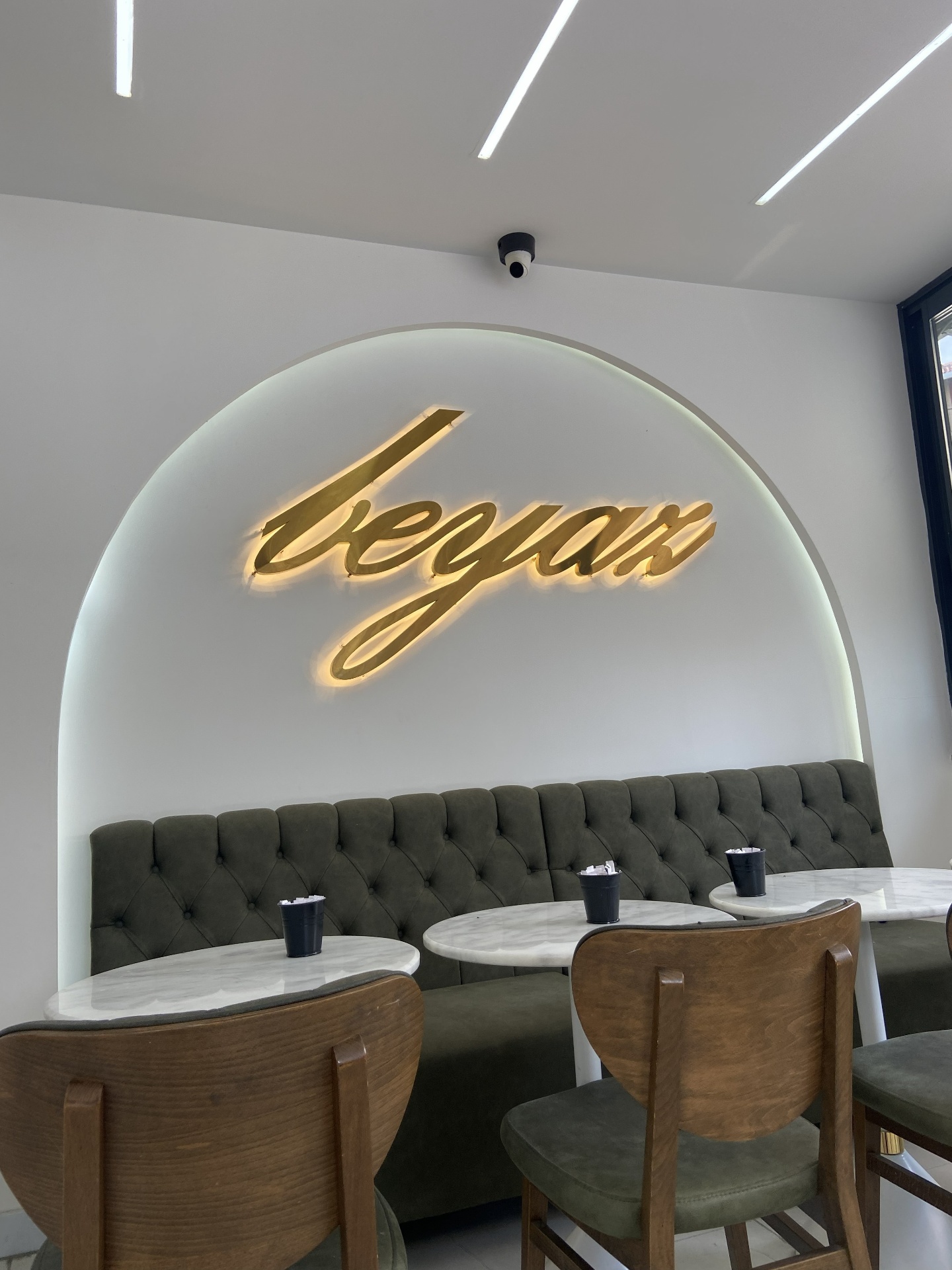 Altın 'beyaz fırın' logolu kemer duvarı ve yeşil kadife oturma alanı